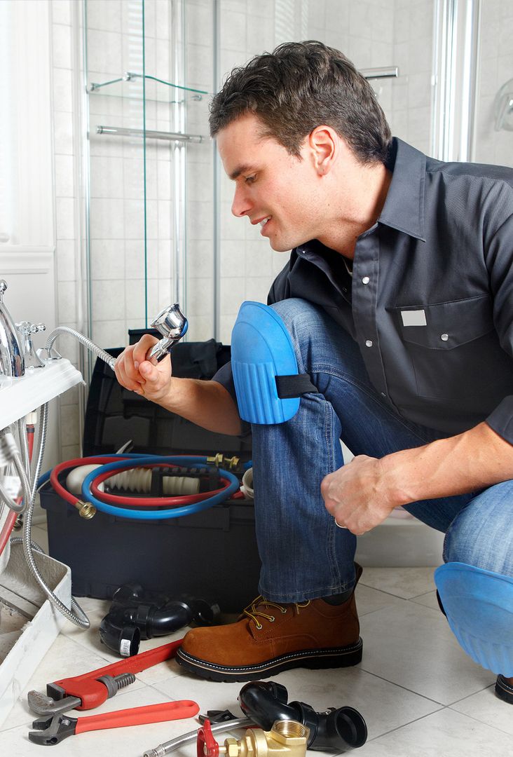 Ein Mitarbeiter arbeitet an einer Sanitärinstallation